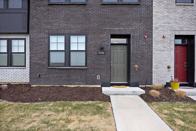 doorway to property with brick siding