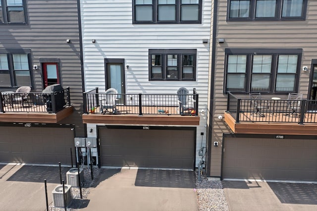 rear view of house featuring a garage and cooling unit