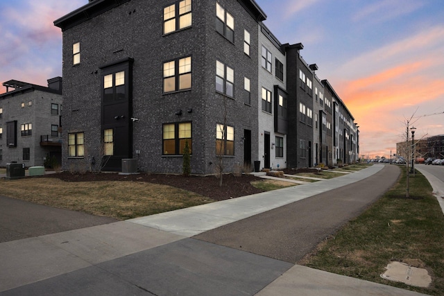 property at dusk featuring central AC unit
