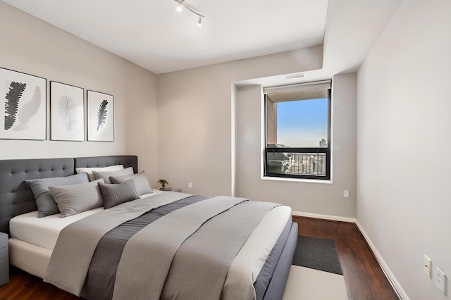 500 Grant St Unit 1711, Minneapolis, MN 55404 - bedroom with visible vents, baseboards, dark wood-style floors, and rail lighting