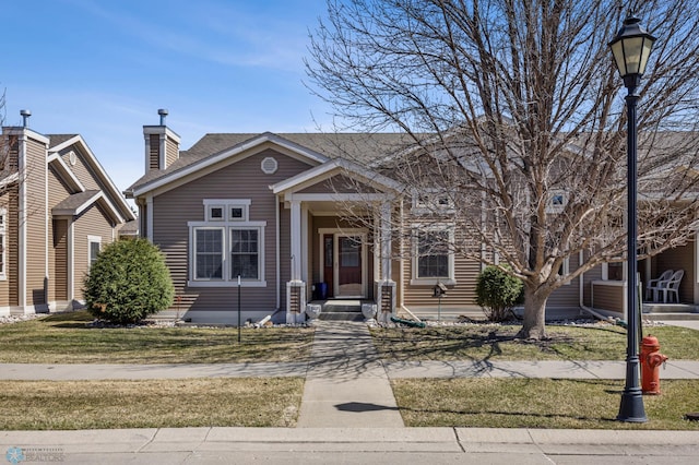 view of front of property with a shingled roof and a front lawn