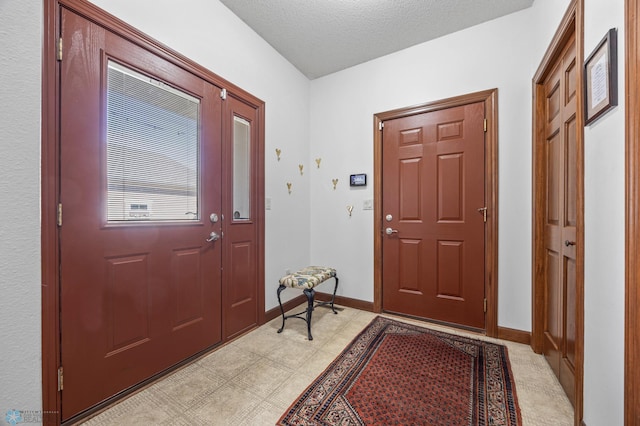 entrance foyer with a textured ceiling and baseboards