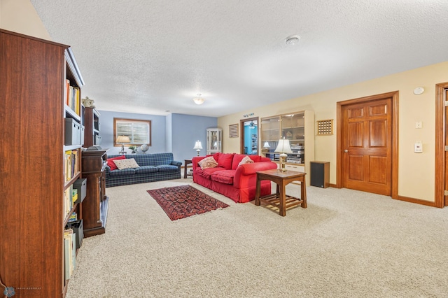 carpeted living area with a textured ceiling and baseboards
