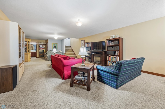 living area with baseboards, stairs, and light carpet