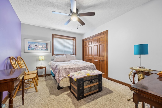 bedroom with light colored carpet, baseboards, a textured ceiling, and a closet