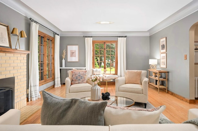 5352 15th Ave S, Minneapolis, MN 55417 - living area featuring arched walkways, wood finished floors, a fireplace, radiator, and crown molding