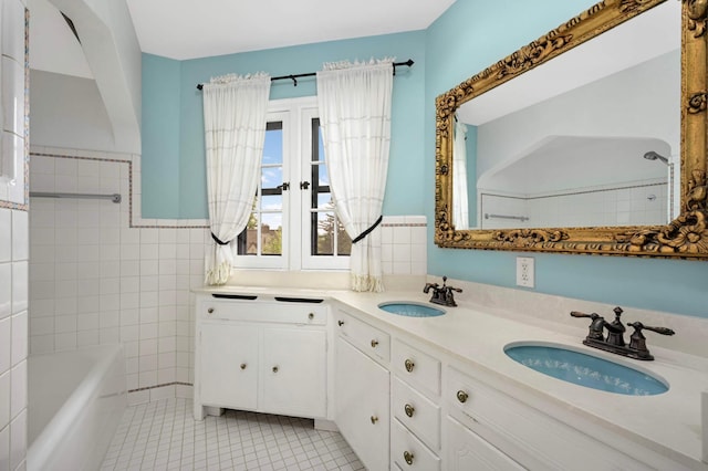 5352 15th Ave S, Minneapolis, MN 55417 - bathroom with tile patterned floors, double vanity, tile walls, and wainscoting