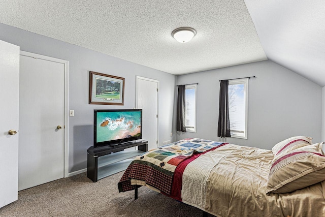 bedroom with carpet flooring, vaulted ceiling, and a textured ceiling