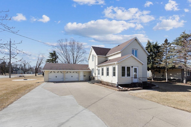 view of front of property featuring an outbuilding, concrete driveway, a shingled roof, and an attached garage