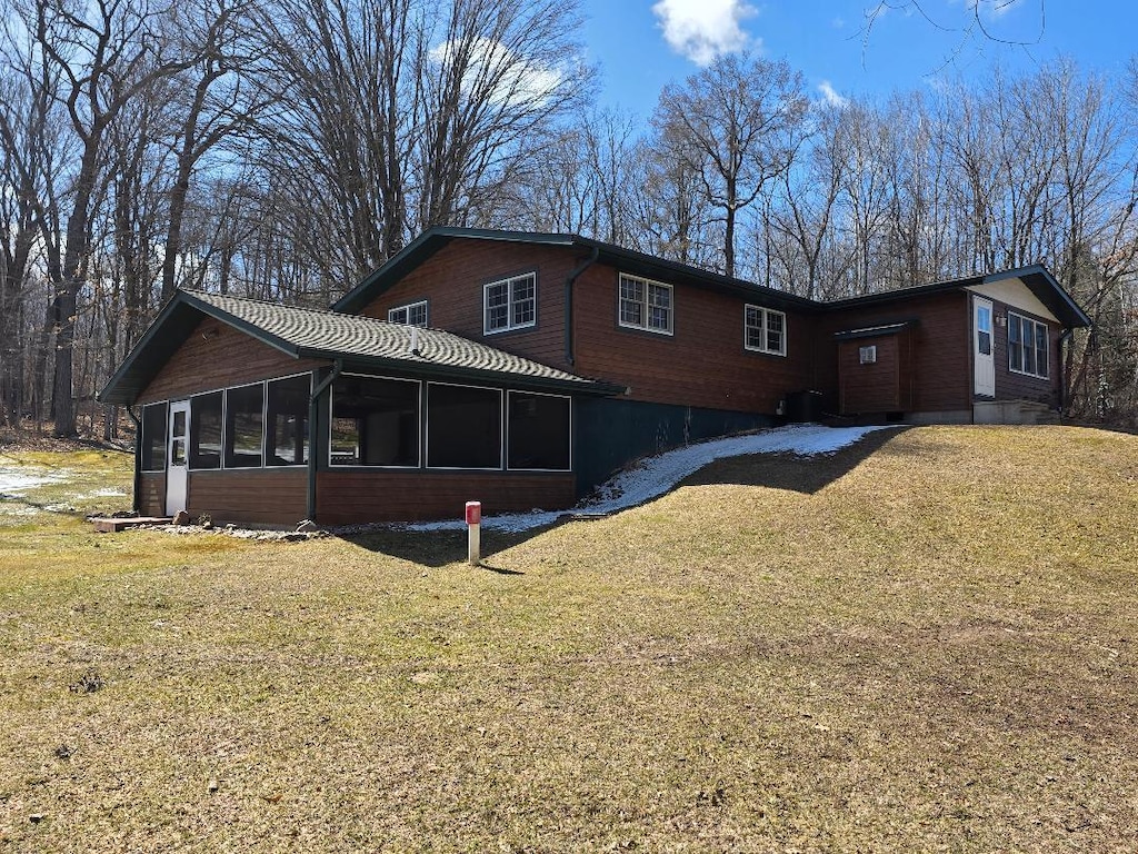 exterior space featuring a sunroom and a yard