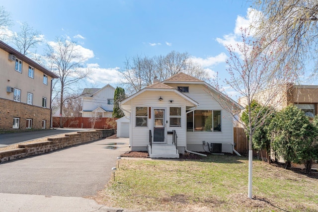 1332 Jersey Ave S, Saint Louis Park, MN 55426 - view of front of home with central AC unit, fence, a front lawn, an outdoor structure, and a detached garage