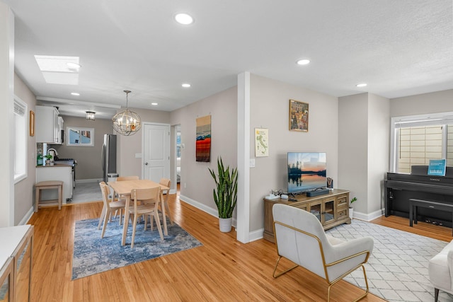 1332 Jersey Ave S, Saint Louis Park, MN 55426 - dining space featuring light wood finished floors, an inviting chandelier, baseboards, and recessed lighting