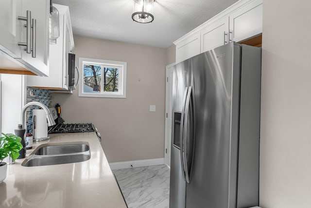 1332 Jersey Ave S, Saint Louis Park, MN 55426 - kitchen with white cabinets, a sink, marble finish floor, light countertops, and appliances with stainless steel finishes
