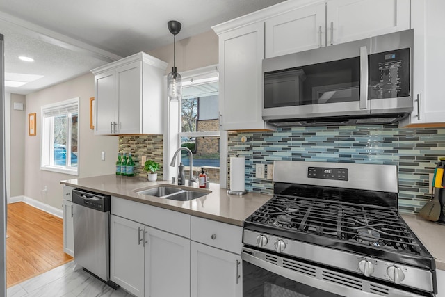 1332 Jersey Ave S, Saint Louis Park, MN 55426 - kitchen featuring appliances with stainless steel finishes, a sink, white cabinetry, and light countertops