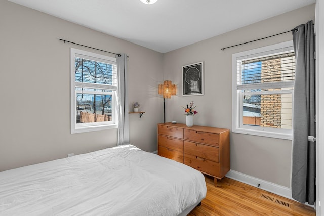 1332 Jersey Ave S, Saint Louis Park, MN 55426 - bedroom with baseboards, light wood finished floors, multiple windows, and visible vents