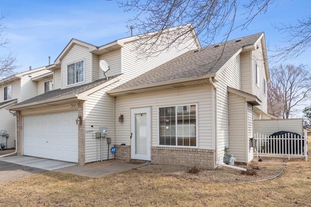 view of front of house with fence, an attached garage, driveway, brick siding, and a shingled roof
