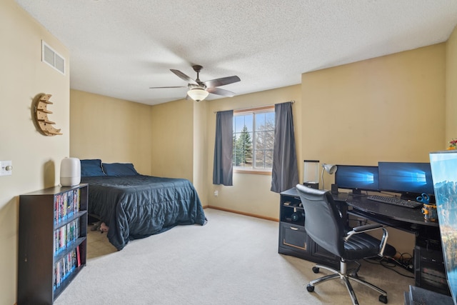 bedroom featuring baseboards, a textured ceiling, carpet floors, visible vents, and a ceiling fan
