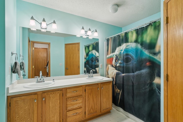 bathroom with double vanity, a sink, tile patterned floors, and a textured ceiling