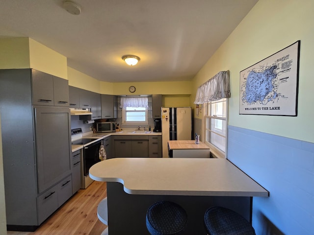 16099 Twilight Rd, Kathio Twp, MN 56359 - kitchen featuring gray cabinetry, electric range oven, stainless steel microwave, freestanding refrigerator, and a peninsula
