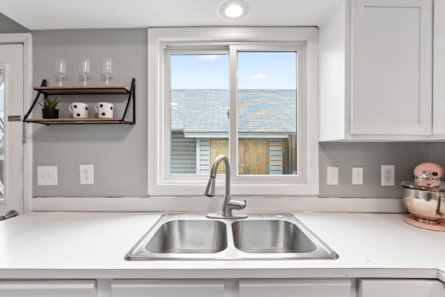7986 Lad Pkwy, Brooklyn Park, MN 55443 - kitchen with a sink, light countertops, and white cabinetry