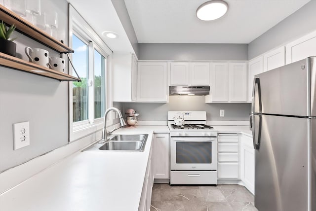 7986 Lad Pkwy, Brooklyn Park, MN 55443 - kitchen featuring freestanding refrigerator, white range with gas cooktop, under cabinet range hood, a sink, and white cabinetry