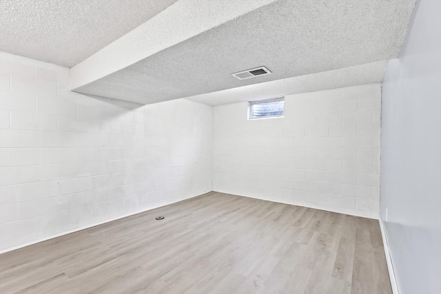 7986 Lad Pkwy, Brooklyn Park, MN 55443 - below grade area with wood finished floors, concrete block wall, and a textured ceiling
