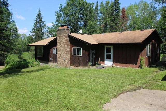 42491 432nd Ln, Aitkin, MN 56431 - rear view of house with board and batten siding, a chimney, and a lawn