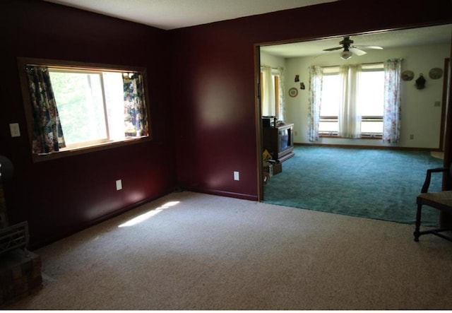 42491 432nd Ln, Aitkin, MN 56431 - unfurnished room with baseboards, carpet floors, ceiling fan, and a wood stove