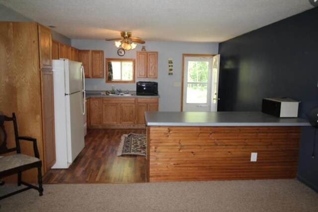 42491 432nd Ln, Aitkin, MN 56431 - kitchen with black microwave, a healthy amount of sunlight, a peninsula, and freestanding refrigerator