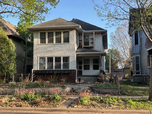 view of front facade with a shingled roof and brick siding