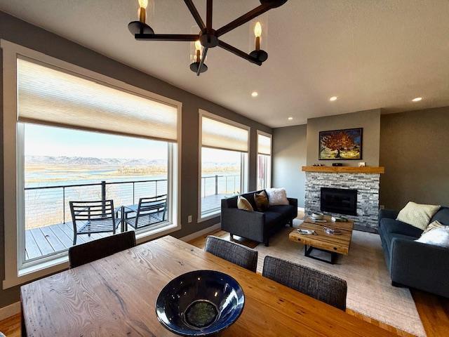 817 2nd St N, Brownsville, MN 55919 - living area featuring wood finished floors, a stone fireplace, baseboards, ceiling fan, and recessed lighting