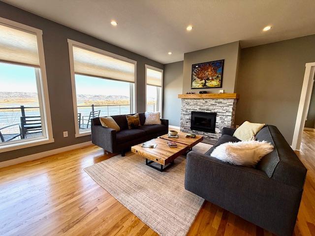 817 2nd St N, Brownsville, MN 55919 - living area with light wood finished floors, a fireplace, recessed lighting, baseboards, and a water view