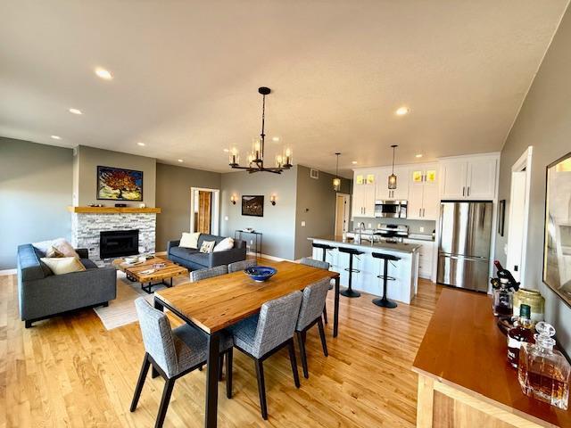 817 2nd St N, Brownsville, MN 55919 - dining area with recessed lighting, a fireplace, light wood finished floors, and a notable chandelier