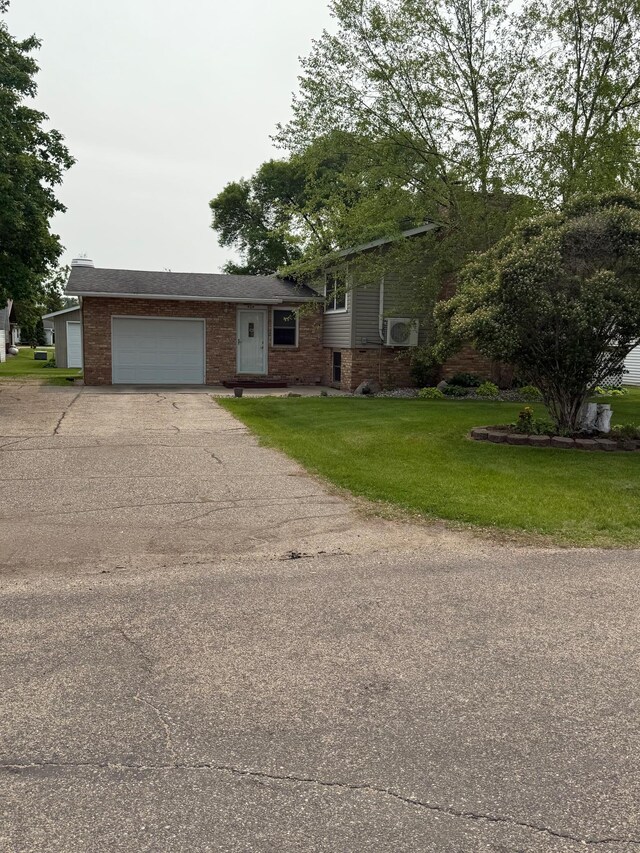 404 Balmoral Ave, Henning, MN 56551 - split level home with a garage, concrete driveway, brick siding, and a front yard
