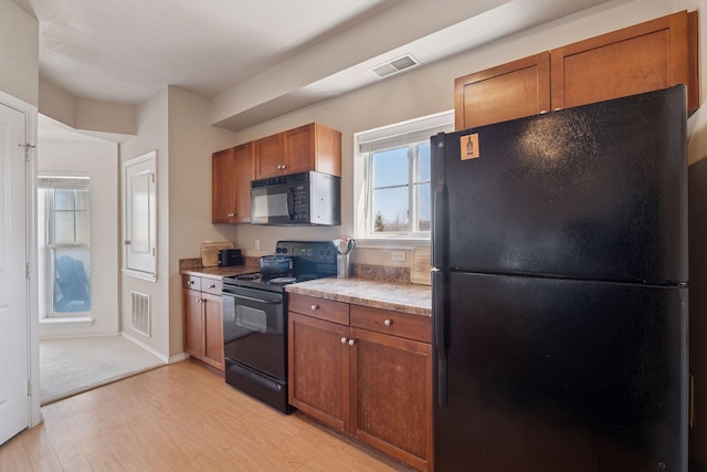 13560 Technology Dr Unit 1210, Eden Prairie, MN 55344 - kitchen featuring black appliances, light wood-style flooring, brown cabinets, and light countertops