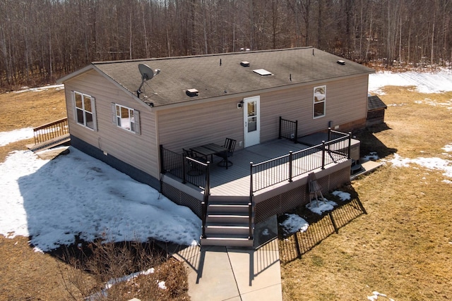 42479 US-71, Laporte, MN 56461 - snow covered back of property with a wooden deck, a shingled roof, and a view of trees