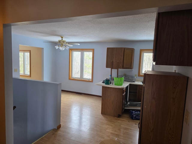 kitchen featuring a textured ceiling, a healthy amount of sunlight, and light wood finished floors