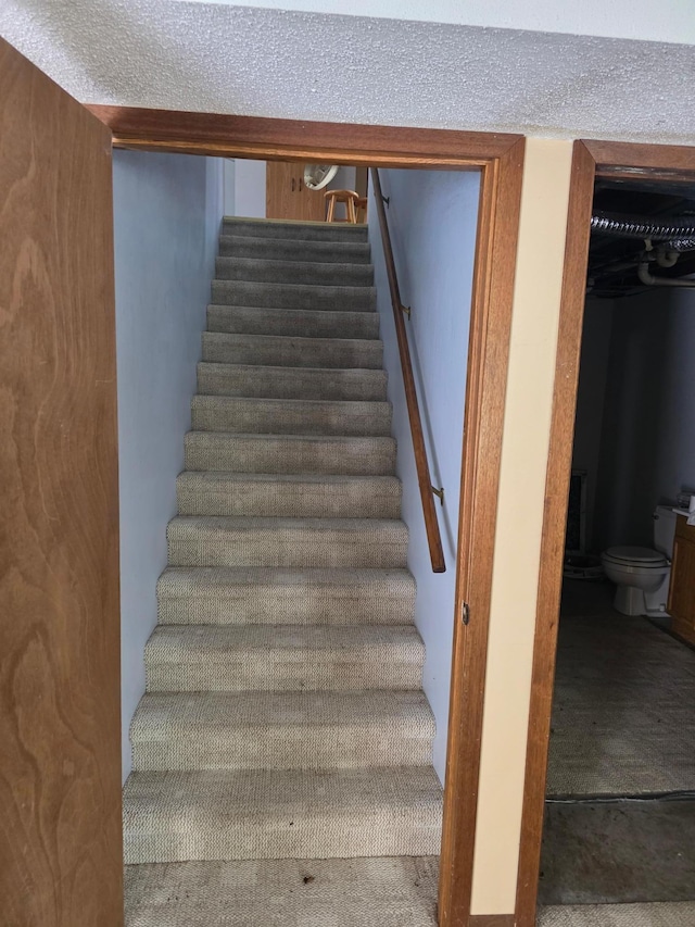 stairs with a textured ceiling