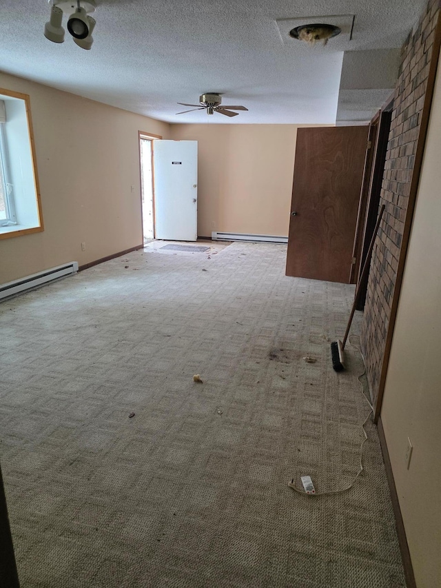 spare room featuring baseboards, baseboard heating, and a textured ceiling