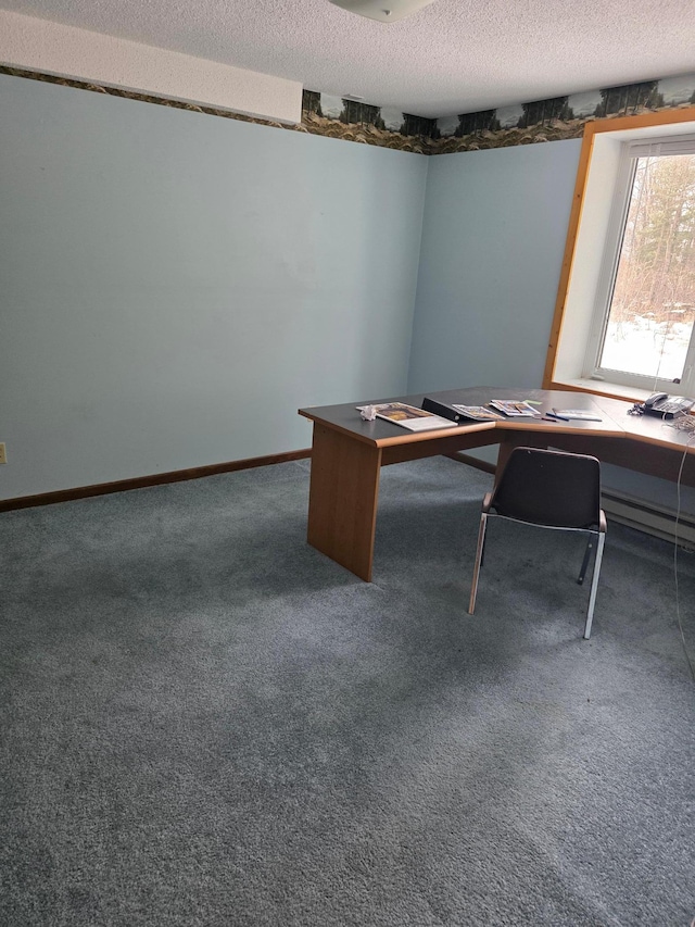 unfurnished office with carpet flooring, baseboards, and a textured ceiling