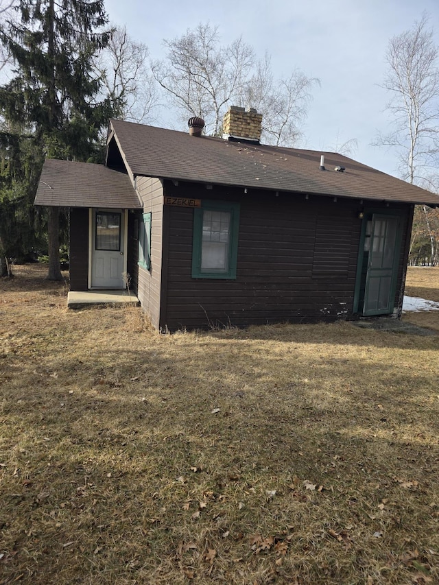 rear view of property with a lawn and a chimney