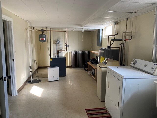 713 Maple Dr, Aurora, MN 55705 - laundry room featuring light floors, radiator, washing machine and dryer, and electric water heater