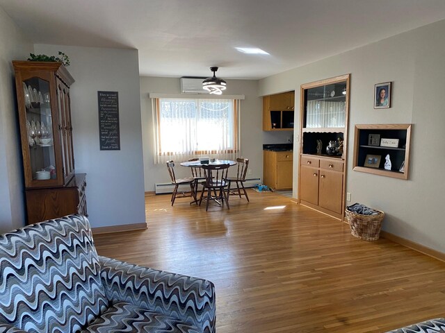 713 Maple Dr, Aurora, MN 55705 - dining space with a baseboard radiator, baseboards, a wall mounted AC, and light wood-type flooring