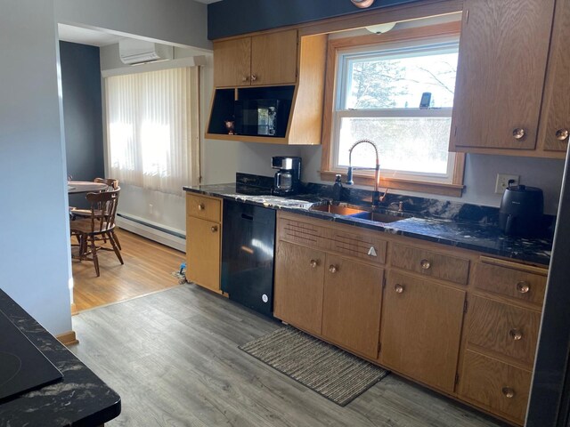 713 Maple Dr, Aurora, MN 55705 - kitchen with baseboard heating, an AC wall unit, a sink, dishwasher, and light wood-style flooring