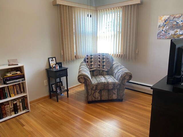 713 Maple Dr, Aurora, MN 55705 - living area with baseboards, wood finished floors, and a baseboard radiator