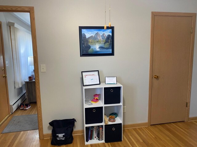 713 Maple Dr, Aurora, MN 55705 - hall with a baseboard radiator, wood finished floors, and baseboards