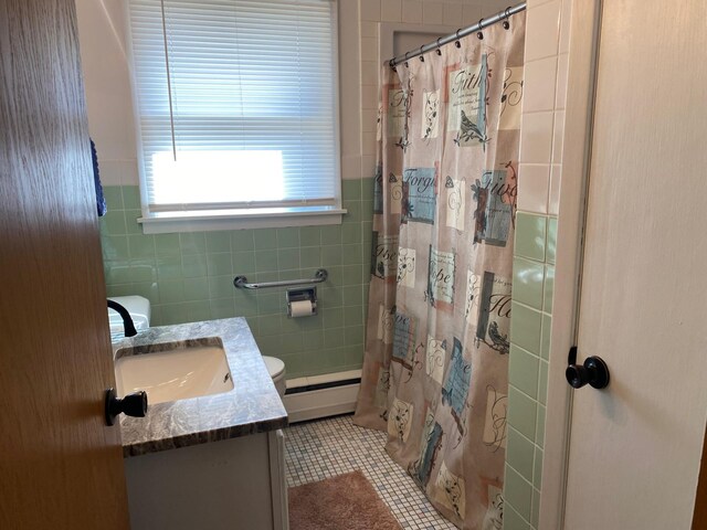 713 Maple Dr, Aurora, MN 55705 - full bathroom featuring a baseboard heating unit, vanity, tile walls, tile patterned flooring, and a shower with shower curtain