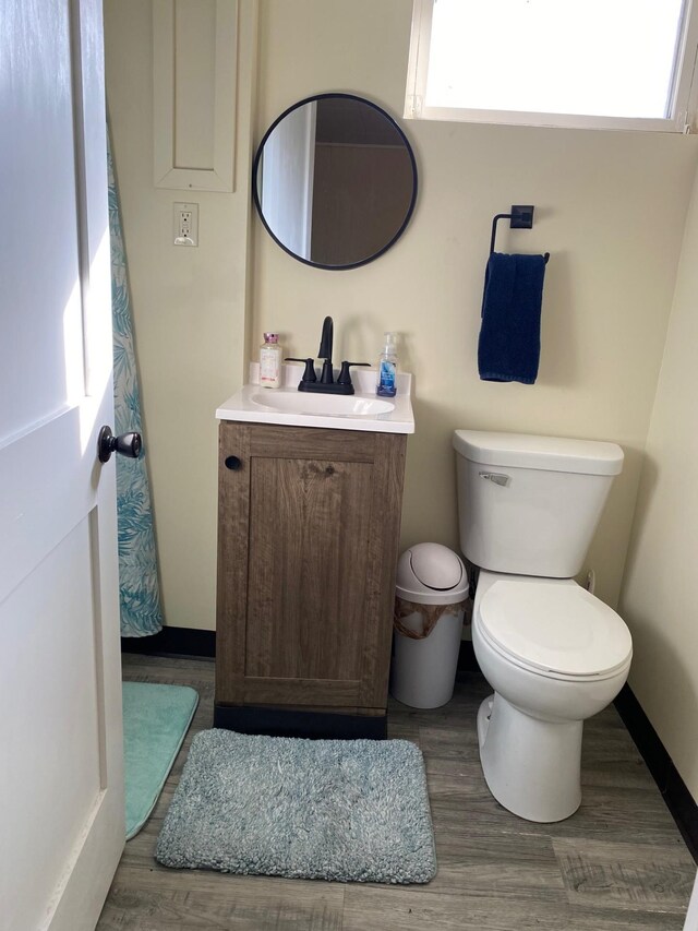 713 Maple Dr, Aurora, MN 55705 - bathroom featuring baseboards, wood finished floors, vanity, and toilet