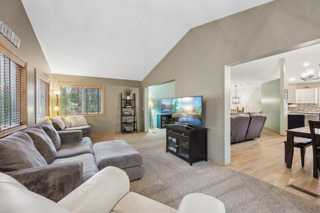 108 Serenity Cir, Buffalo, MN 55313 - living area featuring a chandelier, high vaulted ceiling, carpet floors, and baseboards