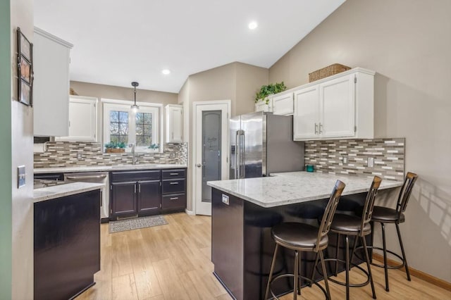 108 Serenity Cir, Buffalo, MN 55313 - kitchen with stainless steel appliances, a peninsula, white cabinetry, a sink, and light stone counters